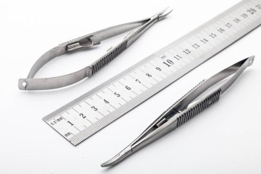 Çelik cerrahi aletler ve laboratuvar ekipmanları beyaz arka planda izole edilmiş. Profesyonel klinik aletleri. Tıbbi, cerrahi, ambulans ve veteriner konsepti. Yumuşak seçici odaklı yakın plan