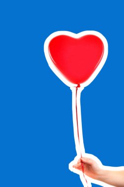 Kadın eli kırmızı kauçuk, şişme kalp şeklinde balon tutuyor. Aşk, ilişki, sevgililer günü ve doğum günü kutlaması konsepti. Boş kopya alanı olan dergi tarzı moda kolajı