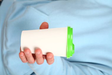 İnsan eli plastik kapaklı boş bir kahve fincanı tutar. Tek kullanımlık fincana çay ya da kahve konsepti. Metin veya logo için yeri ve yeri kopyala. Beyaz bir arkaplanda izole edilmiş