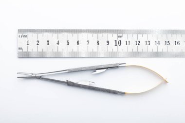 Çelik cerrahi aletler ve laboratuvar ekipmanları beyaz arka planda izole edilmiş. Profesyonel klinik aletleri. Tıbbi, cerrahi, ambulans ve veteriner konsepti. Yumuşak seçici odaklı yakın plan