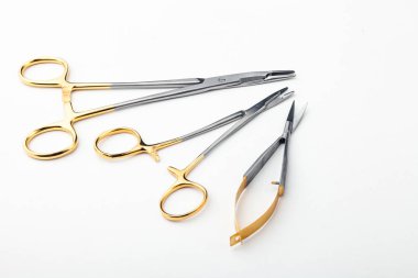 Çelik cerrahi aletler ve laboratuvar ekipmanları beyaz arka planda izole edilmiş. Profesyonel klinik aletleri. Tıbbi, cerrahi, ambulans ve veteriner konsepti. Yumuşak seçici odaklı yakın plan