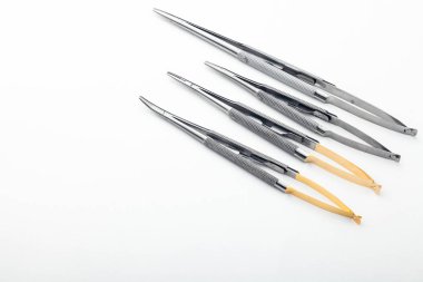 Çelik cerrahi aletler ve laboratuvar ekipmanları beyaz arka planda izole edilmiş. Profesyonel klinik aletleri. Tıbbi, cerrahi, ambulans ve veteriner konsepti. Yumuşak seçici odaklı yakın plan