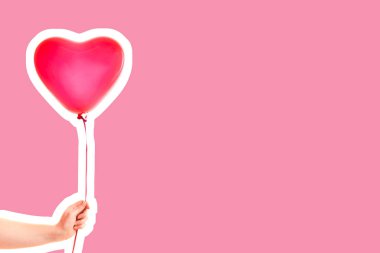 Kadın eli kırmızı kauçuk, şişme kalp şeklinde balon tutuyor. Aşk, ilişki, sevgililer günü ve doğum günü kutlaması konsepti. Boş kopya alanı olan dergi tarzı moda kolajı