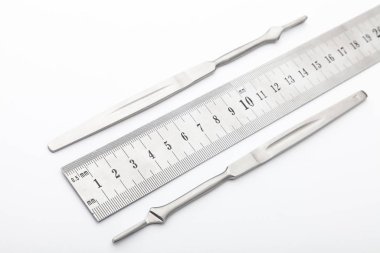 Çelik cerrahi aletler ve laboratuvar ekipmanları beyaz arka planda izole edilmiş. Profesyonel klinik aletleri. Tıbbi, cerrahi, ambulans ve veteriner konsepti. Yumuşak seçici odaklı yakın plan