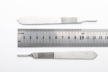 Çelik cerrahi aletler ve laboratuvar ekipmanları beyaz arka planda izole edilmiş. Profesyonel klinik aletleri. Tıbbi, cerrahi, ambulans ve veteriner konsepti. Yumuşak seçici odaklı yakın plan