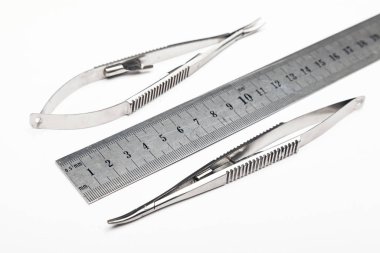 Çelik cerrahi aletler ve laboratuvar ekipmanları beyaz arka planda izole edilmiş. Profesyonel klinik aletleri. Tıbbi, cerrahi, ambulans ve veteriner konsepti. Yumuşak seçici odaklı yakın plan