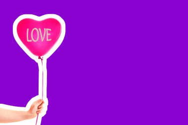 Kadın eli kırmızı kauçuk, şişme kalp şeklinde balon tutuyor. Aşk, ilişki, sevgililer günü ve doğum günü kutlaması konsepti. Boş kopya alanı olan dergi tarzı moda kolajı