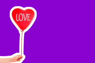 Kadın eli kırmızı kauçuk, şişme kalp şeklinde balon tutuyor. Aşk, ilişki, sevgililer günü ve doğum günü kutlaması konsepti. Boş kopya alanı olan dergi tarzı moda kolajı