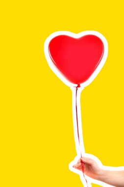 Kadın eli kırmızı kauçuk, şişme kalp şeklinde balon tutuyor. Aşk, ilişki, sevgililer günü ve doğum günü kutlaması konsepti. Boş kopya alanı olan dergi tarzı moda kolajı