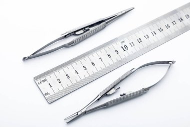 Çelik cerrahi aletler ve laboratuvar ekipmanları beyaz arka planda izole edilmiş. Profesyonel klinik aletleri. Tıbbi, cerrahi, ambulans ve veteriner konsepti. Yumuşak seçici odaklı yakın plan