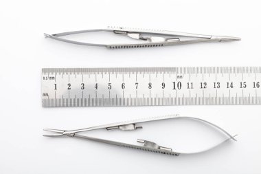 Çelik cerrahi aletler ve laboratuvar ekipmanları beyaz arka planda izole edilmiş. Profesyonel klinik aletleri. Tıbbi, cerrahi, ambulans ve veteriner konsepti. Yumuşak seçici odaklı yakın plan