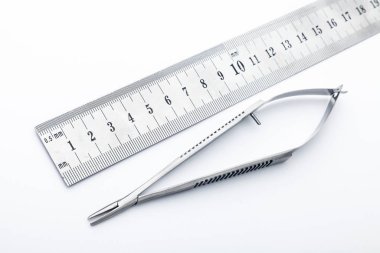 Çelik cerrahi aletler ve laboratuvar ekipmanları beyaz arka planda izole edilmiş. Profesyonel klinik aletleri. Tıbbi, cerrahi, ambulans ve veteriner konsepti. Yumuşak seçici odaklı yakın plan