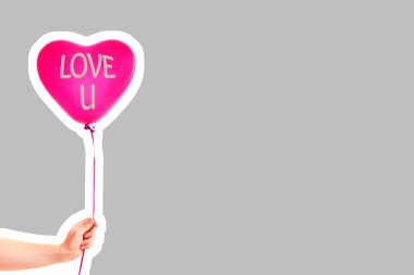 Kadın eli kırmızı kauçuk, şişme kalp şeklinde balon tutuyor. Aşk, ilişki, sevgililer günü ve doğum günü kutlaması konsepti. Boş kopya alanı olan dergi tarzı moda kolajı