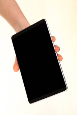 İnsan eli, avucunda boş bir krom ekran olan modern bir akıllı telefonu tutar. Teknoloji ve reklam kavramı. Ayrıntılı yakın çekim stüdyo çekimi soyut beyaz arka planda izole