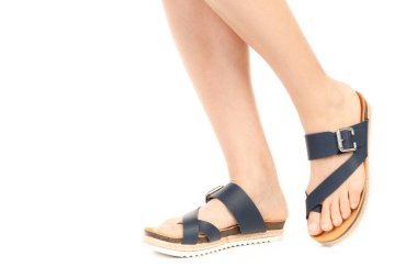 Bayan giysi ayakkabısı. Deri sandalet giyen uzun ince kadın bacakları. Fotokopi alanı olan moda modeli. Klasik ve günlük kıyafet konsepti. Ayrıntılı yakın çekim stüdyo çekimi beyaz arkaplanda izole edildi