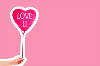 Kadın eli kırmızı kauçuk, şişme kalp şeklinde balon tutuyor. Aşk, ilişki, sevgililer günü ve doğum günü kutlaması konsepti. Boş kopya alanı olan dergi tarzı moda kolajı