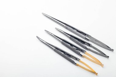 Çelik cerrahi aletler ve laboratuvar ekipmanları beyaz arka planda izole edilmiş. Profesyonel klinik aletleri. Tıbbi, cerrahi, ambulans ve veteriner konsepti. Yumuşak seçici odaklı yakın plan