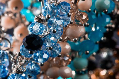 Güzel ve zarif el yapımı mücevher kolye ve renkli parlak boncuklar. Moda ve el işi aksesuarları. Soyut bulanık arkaplan üzerine yumuşak seçici odak ile sanat yakın plan