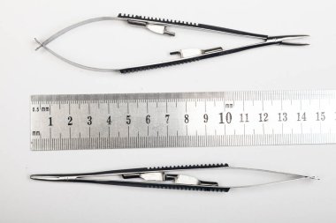 Çelik cerrahi aletler ve laboratuvar ekipmanları beyaz arka planda izole edilmiş. Profesyonel klinik aletleri. Tıbbi, cerrahi, ambulans ve veteriner konsepti. Yumuşak seçici odaklı yakın plan