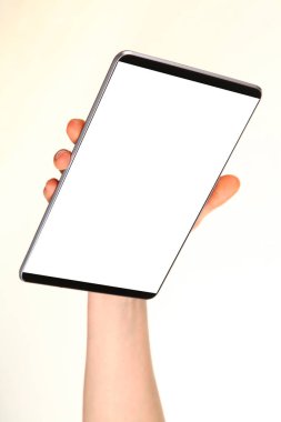 İnsan eli, avucunda boş bir krom ekran olan modern bir akıllı telefonu tutar. Teknoloji ve reklam kavramı. Ayrıntılı yakın çekim stüdyo çekimi soyut beyaz arka planda izole