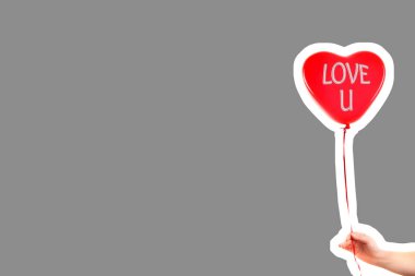 Kadın eli kırmızı kauçuk, şişme kalp şeklinde balon tutuyor. Aşk, ilişki, sevgililer günü ve doğum günü kutlaması konsepti. Boş kopya alanı olan dergi tarzı moda kolajı