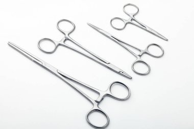 Çelik cerrahi aletler ve laboratuvar ekipmanları beyaz arka planda izole edilmiş. Profesyonel klinik aletleri. Tıbbi, cerrahi, ambulans ve veteriner konsepti. Yumuşak seçici odaklı yakın plan