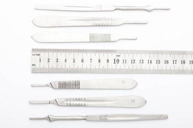 Çelik cerrahi aletler ve laboratuvar ekipmanları beyaz arka planda izole edilmiş. Profesyonel klinik aletleri. Tıbbi, cerrahi, ambulans ve veteriner konsepti. Yumuşak seçici odaklı yakın plan