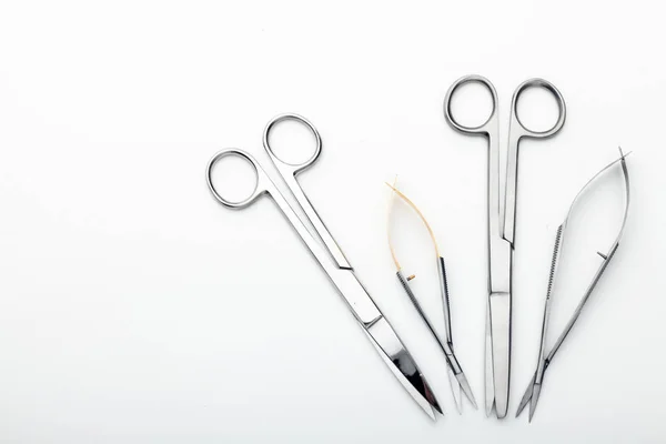 Çelik cerrahi aletler ve laboratuvar ekipmanları beyaz arka planda izole edilmiş. Profesyonel klinik aletleri. Tıbbi, cerrahi, ambulans ve veteriner konsepti. Yumuşak seçici odaklı yakın plan