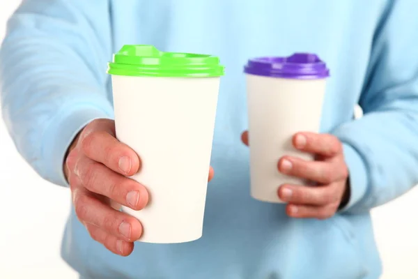 Human hand holds a blank paper Coffee cup with plastic cap. Concept of tea or coffee to go in a disposable mug. Mockup with copy space and place for text or logo. Isolated on a white background