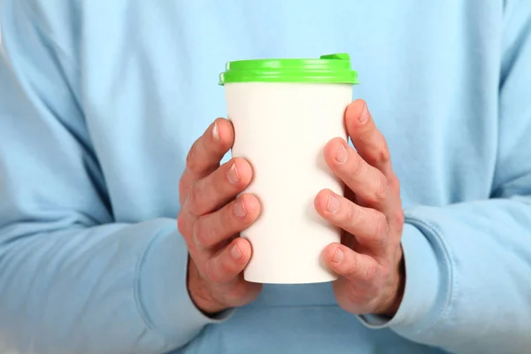 İnsan eli plastik kapaklı boş bir kahve fincanı tutar. Tek kullanımlık fincana çay ya da kahve konsepti. Metin veya logo için yeri ve yeri kopyala. Beyaz bir arkaplanda izole edilmiş