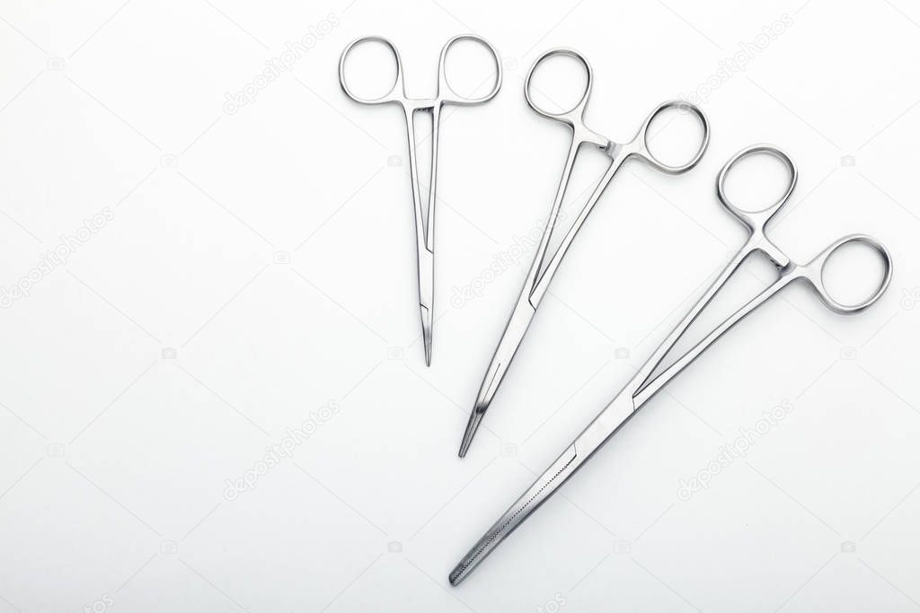 Steel surgical tools and laboratory equipment isolated on a white background. Professional clinic instruments. Medical, surgery, ambulance and veterinarian concept. Closeup with soft selective focus