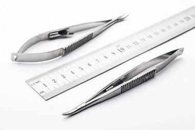 Çelik cerrahi aletler ve laboratuvar ekipmanları beyaz arka planda izole edilmiş. Profesyonel klinik aletleri. Tıbbi, cerrahi, ambulans ve veteriner konsepti. Yumuşak seçici odaklı yakın plan