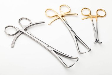 Çelik cerrahi aletler ve laboratuvar ekipmanları beyaz arka planda izole edilmiş. Profesyonel klinik aletleri. Tıbbi, cerrahi, ambulans ve veteriner konsepti. Yumuşak seçici odaklı yakın plan