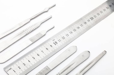 Çelik cerrahi aletler ve laboratuvar ekipmanları beyaz arka planda izole edilmiş. Profesyonel klinik aletleri. Tıbbi, cerrahi, ambulans ve veteriner konsepti. Yumuşak seçici odaklı yakın plan