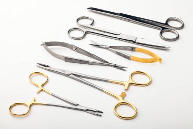 Çelik cerrahi aletler ve laboratuvar ekipmanları beyaz arka planda izole edilmiş. Profesyonel klinik aletleri. Tıbbi, cerrahi, ambulans ve veteriner konsepti. Yumuşak seçici odaklı yakın plan