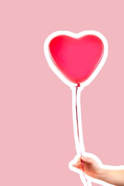 Kadın eli kırmızı kauçuk, şişme kalp şeklinde balon tutuyor. Aşk, ilişki, sevgililer günü ve doğum günü kutlaması konsepti. Boş kopya alanı olan dergi tarzı moda kolajı