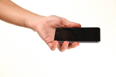 İnsan eli, avucunda boş bir krom ekran olan modern bir akıllı telefonu tutar. Teknoloji ve reklam kavramı. Ayrıntılı yakın çekim stüdyo çekimi soyut beyaz arka planda izole