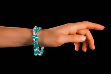 Güzel bir el yapımı mücevher bileziği. Renkli parlak boncuklar ve nötr manikürlü gevşek bir kadın bileği. Moda ve el işi aksesuarları. Yumuşak seçici odaklı yakın plan