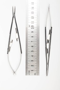 Çelik cerrahi aletler ve laboratuvar ekipmanları beyaz arka planda izole edilmiş. Profesyonel klinik aletleri. Tıbbi, cerrahi, ambulans ve veteriner konsepti. Yumuşak seçici odaklı yakın plan