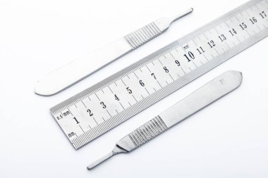 Çelik cerrahi aletler ve laboratuvar ekipmanları beyaz arka planda izole edilmiş. Profesyonel klinik aletleri. Tıbbi, cerrahi, ambulans ve veteriner konsepti. Yumuşak seçici odaklı yakın plan