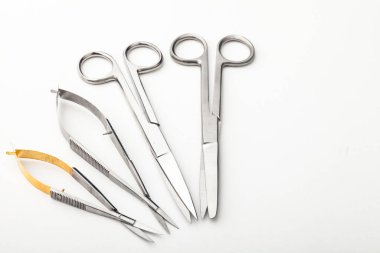Çelik cerrahi aletler ve laboratuvar ekipmanları beyaz arka planda izole edilmiş. Profesyonel klinik aletleri. Tıbbi, cerrahi, ambulans ve veteriner konsepti. Yumuşak seçici odaklı yakın plan