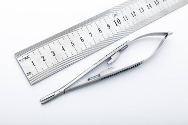 Çelik cerrahi aletler ve laboratuvar ekipmanları beyaz arka planda izole edilmiş. Profesyonel klinik aletleri. Tıbbi, cerrahi, ambulans ve veteriner konsepti. Yumuşak seçici odaklı yakın plan