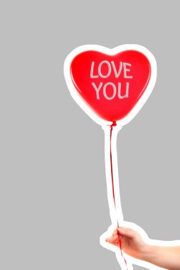 Kadın eli kırmızı kauçuk, şişme kalp şeklinde balon tutuyor. Aşk, ilişki, sevgililer günü ve doğum günü kutlaması konsepti. Boş kopya alanı olan dergi tarzı moda kolajı