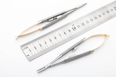 Çelik cerrahi aletler ve laboratuvar ekipmanları beyaz arka planda izole edilmiş. Profesyonel klinik aletleri. Tıbbi, cerrahi, ambulans ve veteriner konsepti. Yumuşak seçici odaklı yakın plan