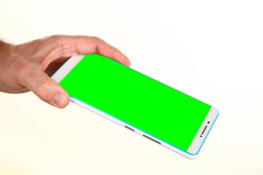 İnsan eli, avucunda boş bir krom ekran olan modern bir akıllı telefonu tutar. Teknoloji ve reklam kavramı. Ayrıntılı yakın çekim stüdyo çekimi soyut beyaz arka planda izole