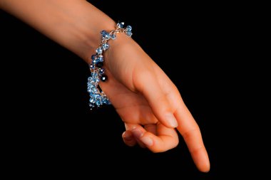 Güzel bir el yapımı mücevher bileziği. Renkli parlak boncuklar ve nötr manikürlü gevşek bir kadın bileği. Moda ve el işi aksesuarları. Yumuşak seçici odaklı yakın plan