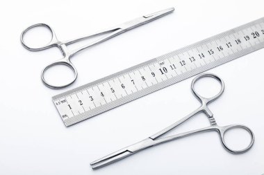 Çelik cerrahi aletler ve laboratuvar ekipmanları beyaz arka planda izole edilmiş. Profesyonel klinik aletleri. Tıbbi, cerrahi, ambulans ve veteriner konsepti. Yumuşak seçici odaklı yakın plan