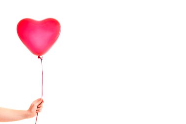 Kadın eli kırmızı kauçuk, şişme kalp şeklinde balon tutuyor. Aşk, ilişki, sevgililer günü ve doğum günü kutlaması konsepti. Stüdyo görüntüsü boş kopya alanı olan bulanık bir arkaplan üzerinde