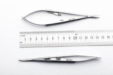 Çelik cerrahi aletler ve laboratuvar ekipmanları beyaz arka planda izole edilmiş. Profesyonel klinik aletleri. Tıbbi, cerrahi, ambulans ve veteriner konsepti. Yumuşak seçici odaklı yakın plan