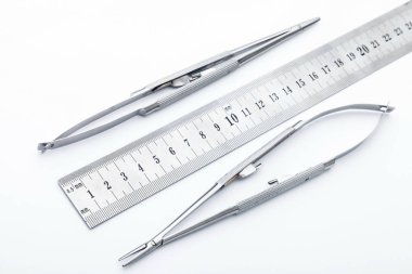 Çelik cerrahi aletler ve laboratuvar ekipmanları beyaz arka planda izole edilmiş. Profesyonel klinik aletleri. Tıbbi, cerrahi, ambulans ve veteriner konsepti. Yumuşak seçici odaklı yakın plan